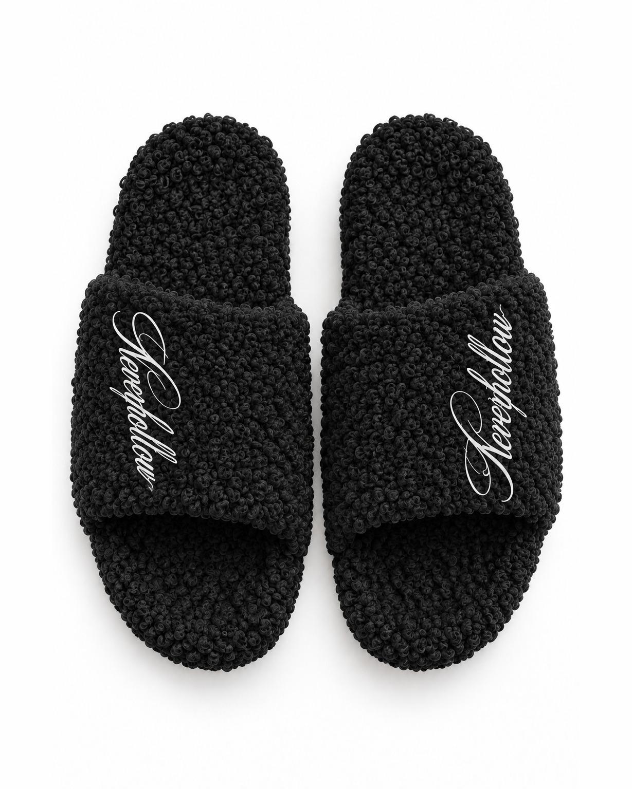 A pair of Haven Slides Obsidian seen from above, with the Neverhollow script on each strap